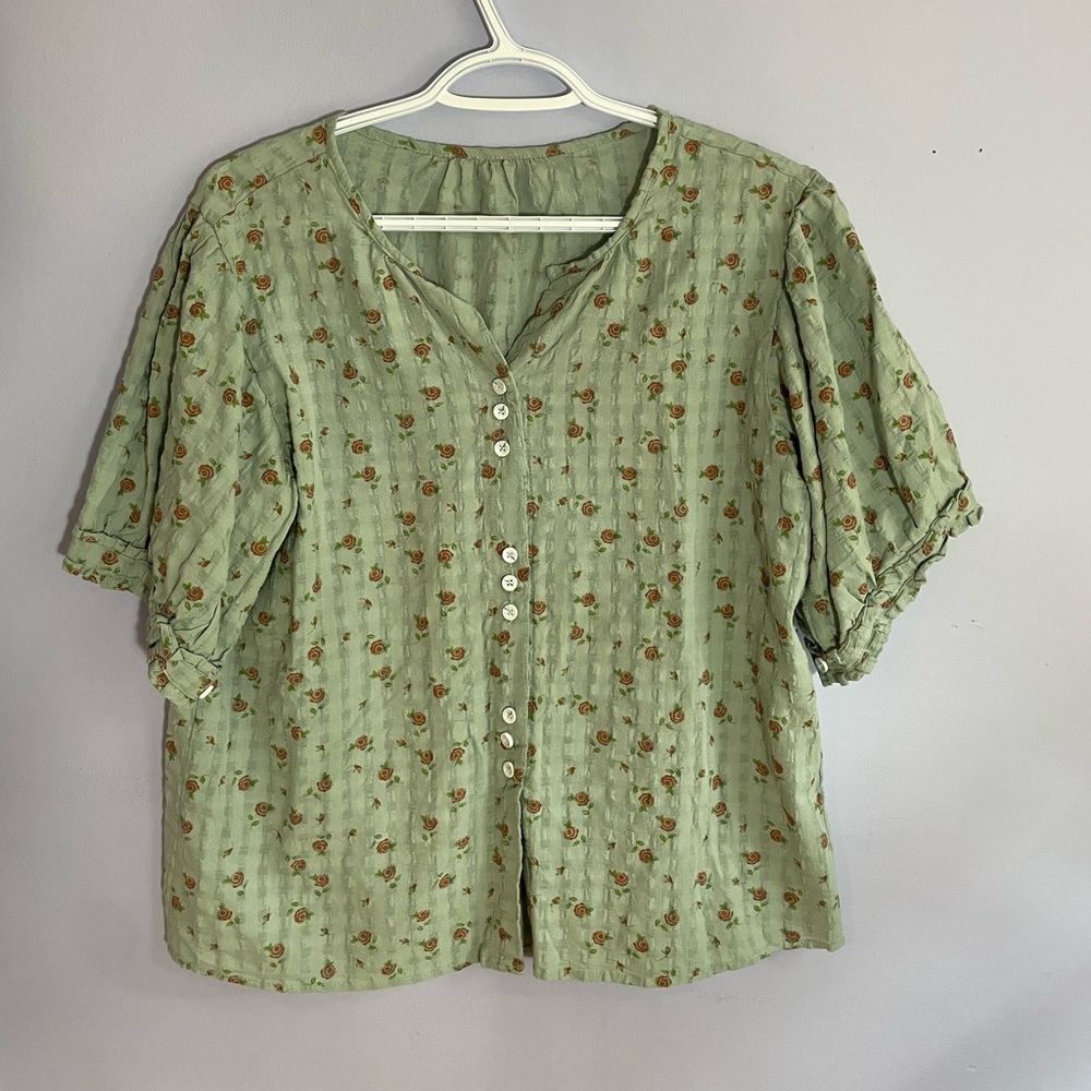 Short-sleeve cotton-linen blouse in pale blue with dainty floral pattern.